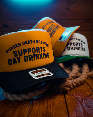 Three trucker caps for German brewery Sudden Death Brewing in different colorways, printed with ‘Supports Day Drinking’